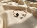 A graceful silver open cuff adorned with a brilliant crystal